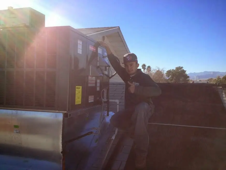 HVAC technician performing AC Tune-Up on a rooftop unit in Wellington